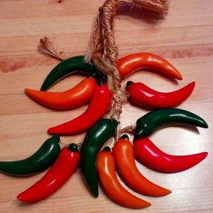 Ceramic vintage chili pepper hanging on the rope .